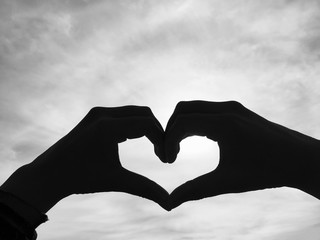 Black And White Heart Silhouette. Love it out there. Close up of heads making a heart. Symbol of love and friendship. Simple shapes made with hands.  Love language with hands. Happy Valentines day. 