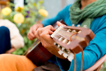 Traveller playing guitar in garden courtyard