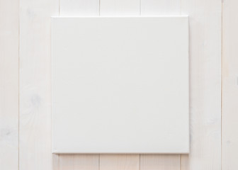 White blank canvas mockup square size on white wood wall for arts painting and photo hanging...
