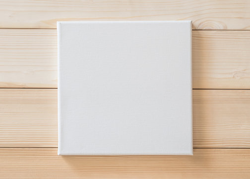 White blank canvas mockup square size on wood wall for arts painting and photo hanging interior decoration