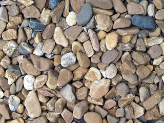 pile of brownish pebble stone texture background, close-up top view
