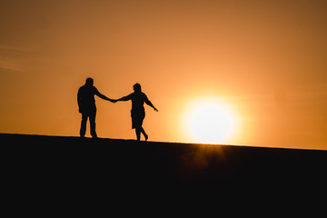 Fototapeta na wymiar Silhouetten von einem Paar das bei Sonnenuntergang tanzt