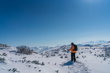Fototapeta na wymiar Mann mit Schneeschuhen geht auf den Berg Gipfel