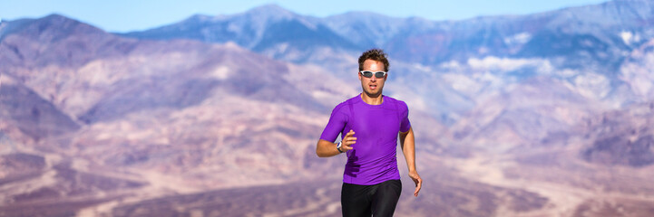 Athlete trail running in desert landscape wearing sunglasses and smartwatch - wearable tech sportswear active people lifestyle banner panorama.
