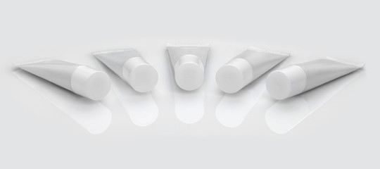 Five tubes of toothpaste on a white background