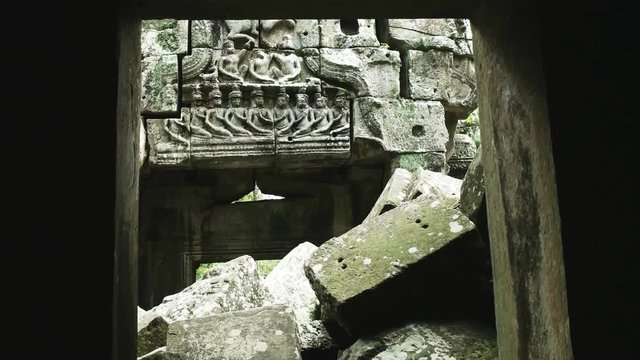 a carved lintel viewed through a doorway of ta nei temple in angkor, cambodia
