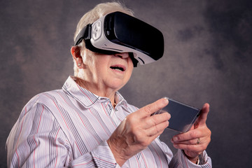 gray hairy elderly woman using virtual reality glasses