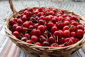 Cherries. Cherry. Organic cherries in basket on a farmer’s market. Red cherry background. Fresh cherries texture. Healthy food concept. 