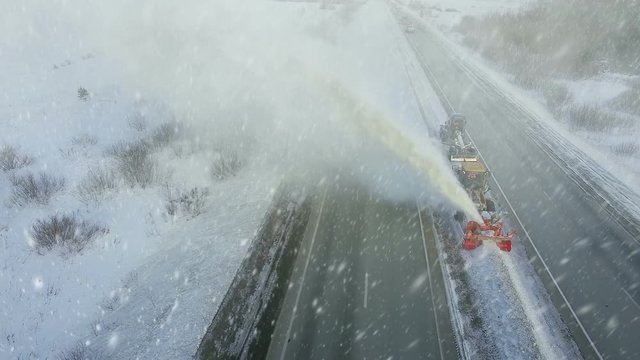 Heavy big storm snow fall, grader clean remove snow, snowplow, snow blower, blast snowfall, winter, road, special vehicle on the highway, cool frozen fountain of snow aerial view