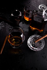 Fototapeta na wymiar Glass of whiskey with smoking cigar.