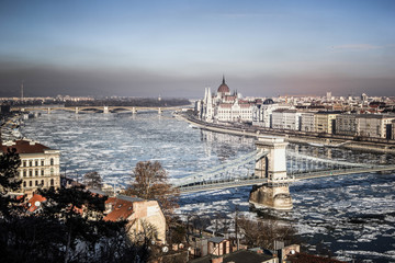 Obraz premium Panorama of Budapest - Parliament, chain bridge, river Danube in the spring with ice drifts, Budapest, Hungary