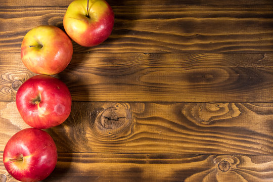 Red apples on wooden table. Top view, copy space