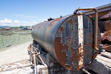 corrosion of steel storage tank near ocean, rusty metal container
