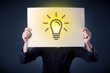 Businessman holding paper with lightbulb