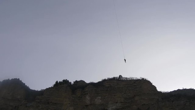 Man hanging on rope
