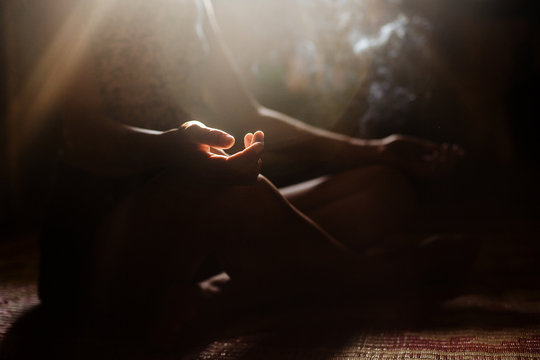 girl's hand lit by the sun in meditation