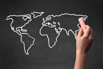 Adult drawing world map on chalkboard
