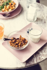 Granola with yogurt on white marble table at coffee shop. Breakfast or lunch time. Healthy lifestyle, slow living, minimalistic concept