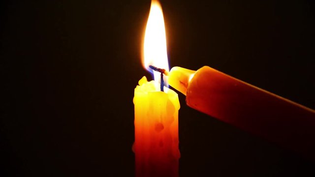 light the yellow candle by flame for pray in dark