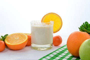 Smoothies with bananas and oranges, a sprig of mint on a white background. Space for text or design.