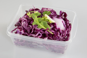healthy vegetarian salad with red cabbage chopped in the plastic take away box
