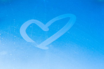 The heart is drawn on the window. Heart on blue sky background