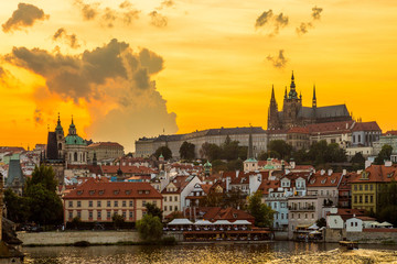 Obraz premium Sunset in Prague with Prague castle, Saint Vitus Cathedral, and the river Vltava.