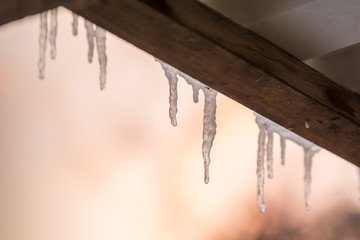 Eiszapfen an einem Dach mit Textfreiraum als winterlicher Hintergrund