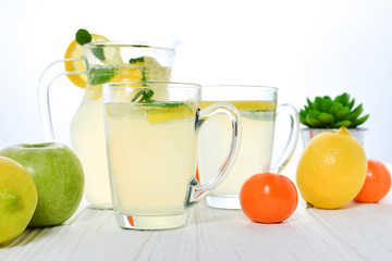 Citrus lemonade water with lemon sliced , healthy and detox water drink in summer on white wooden...