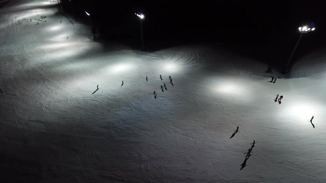 Drone aerial view of skiers on the slope, night skiing at Monte Pora ski resort