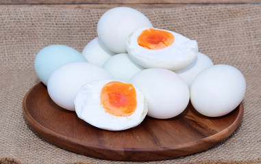 Focus Egg yolk, salted duck eggs in wooden plate on brown sack cloth.