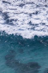 Fototapeta na wymiar White foam of wave in blue water.