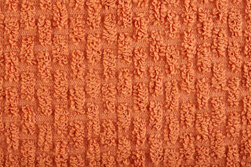orange fabric and texture concept - close up of a towel terry cloth or terry textile background