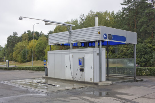 An empty no name standard self-service car wash is located next to the highway