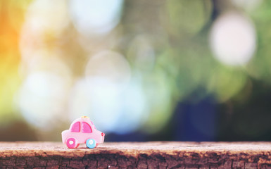 miniature car on wooden mock up over blurred green garden bokeh light for Financial Leasing concept.