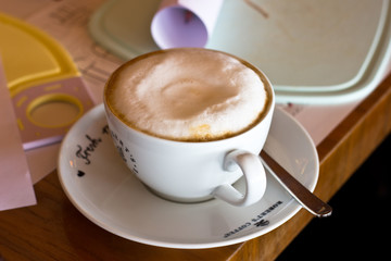 Coffee latte with foam in a white mug on the table