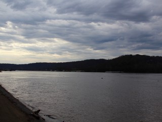 Th overcast skies over the river in the park.