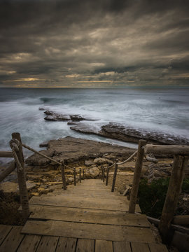 Beautiful rocky beach in the Portuguese coastline in a stormy day. Seascape. Long exposure.