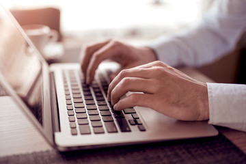 Young man using his laptop, close up.