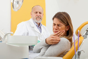 Female patient with toothache at the dentist office