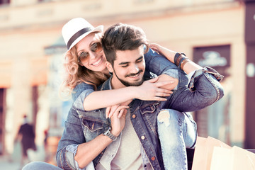 Cheerful smiling couple in love hugging on the street.