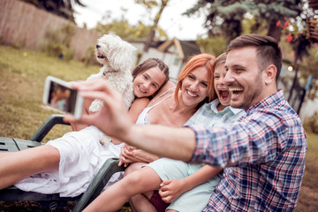 Obraz na płótnie Canvas Happy family smiling at the camera with their dog