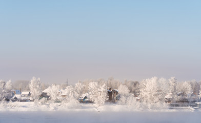 Winter landscape, white snow covered on trees and local houses in urban countryside, in Russia