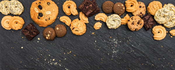 Top view different cookies on table top, Flat lay of various cookies on black stone for background, Prepared cookies food buffet on table for serve - obrazy, fototapety, plakaty