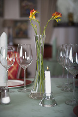Freesias in a vase and empty glasses on a restaurant table. Elegant style.