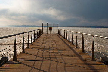 Fototapeta premium Pier. Wooden bridge. The frozen sea.