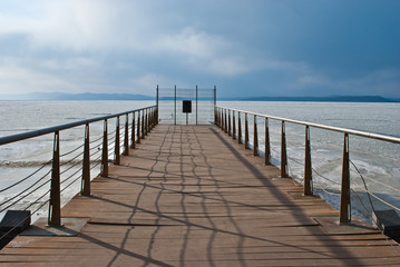 Pier. Wooden bridge. The frozen sea.
