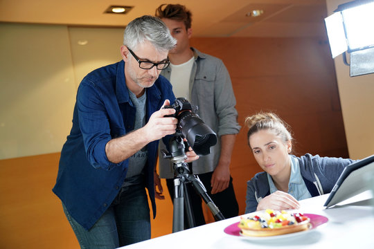 Photographer teaching group of students