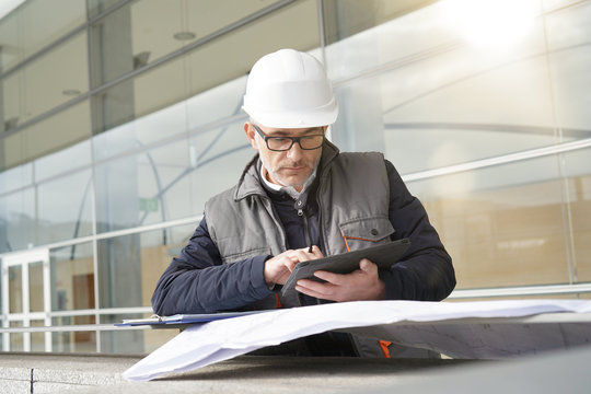 Engineer on site checking project on digital tablet