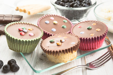 chocolate covered muffins modern wooden stage with chocolate and cinnamon and blueberries